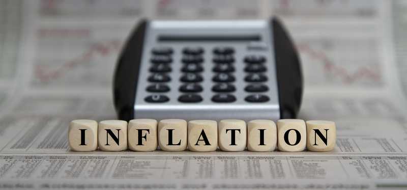 Inflation spelled out on blocks in front of a calculator