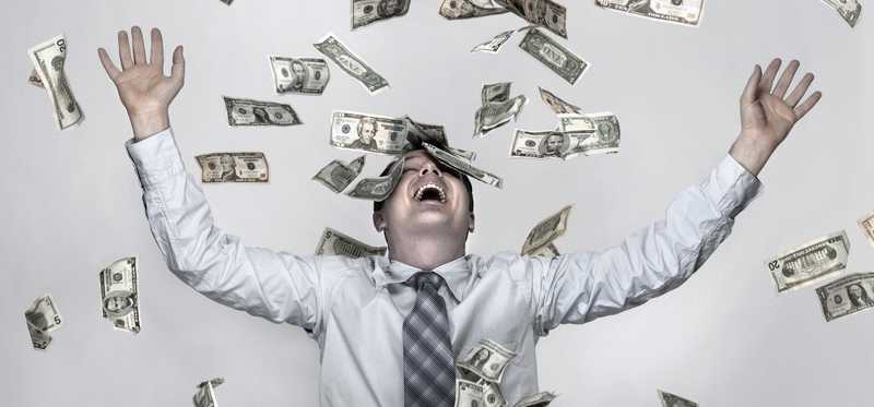 Money raining down on smiling person with hands in the air.