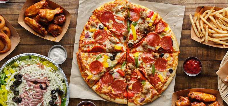 A generic pizza, wings, fries, a salad, and other foods.