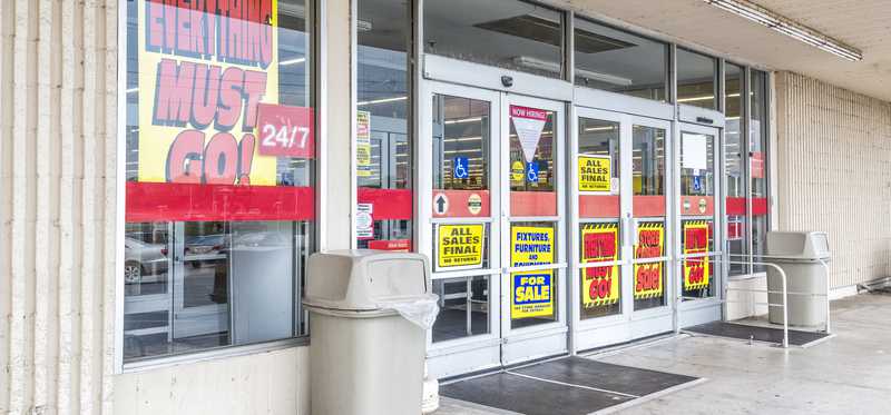 Storefront with Everything Must Go signs in the window.