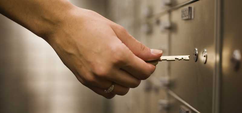 Person using key at safety deposit box.