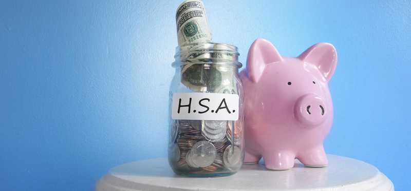 Mason jar filled with spare change next to a piggy bank.