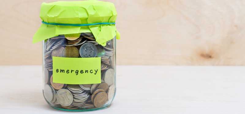 Jar of coins with a Post-it labeled Emergency.