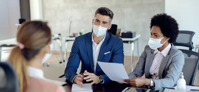 Masked people in a meeting.