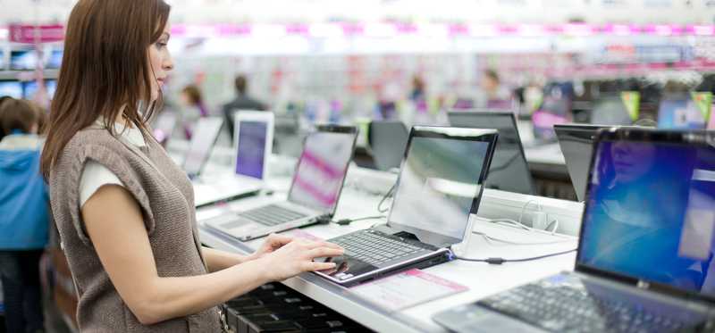 Person shopping for a laptop in a store.