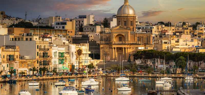 The skyline of a city in Malta at night.