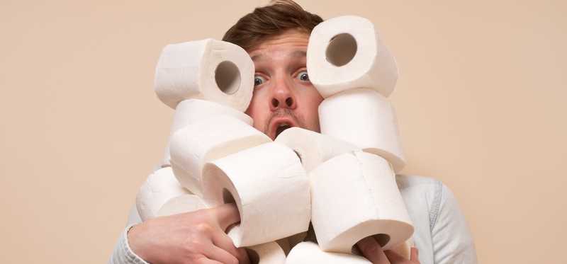 Man juggling rolls of toilet paper