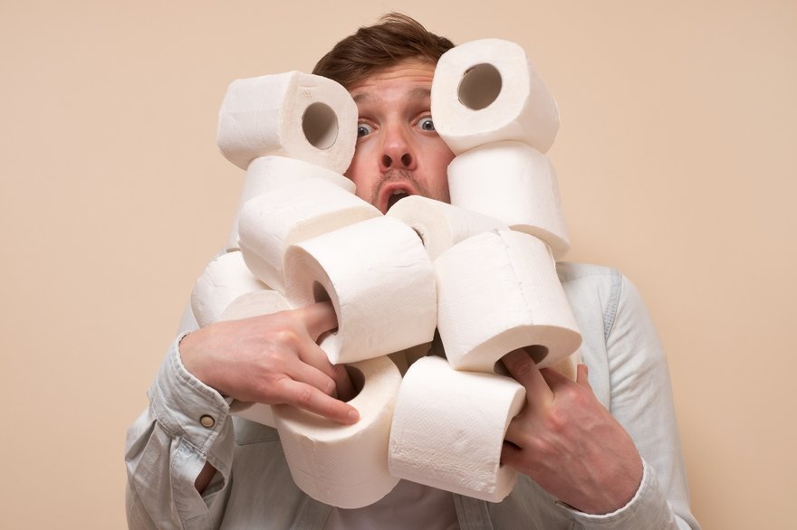 Man juggling rolls of toilet paper