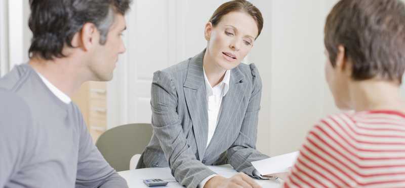 man and woman looking over documents with woman in business suit