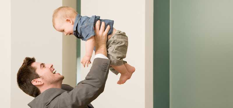Man holding up a baby.