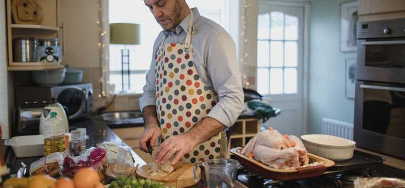 Man in apron preparing food.