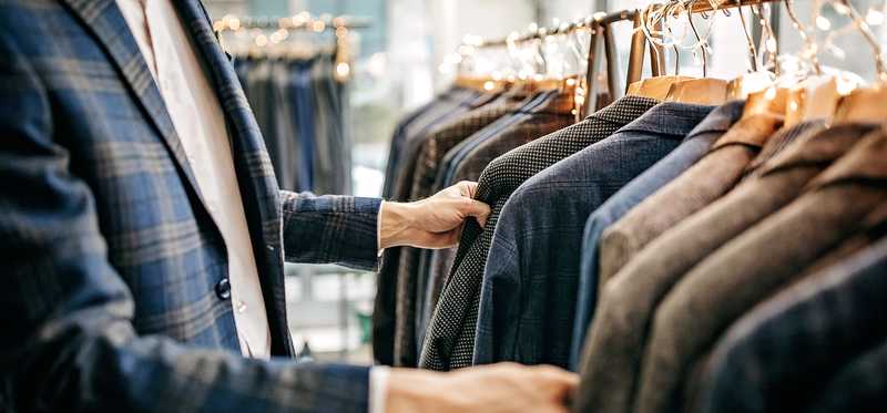 Shopper looking through a rack of sports jackets.