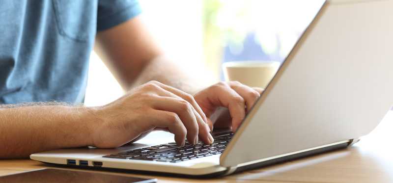 Man typing on laptop.