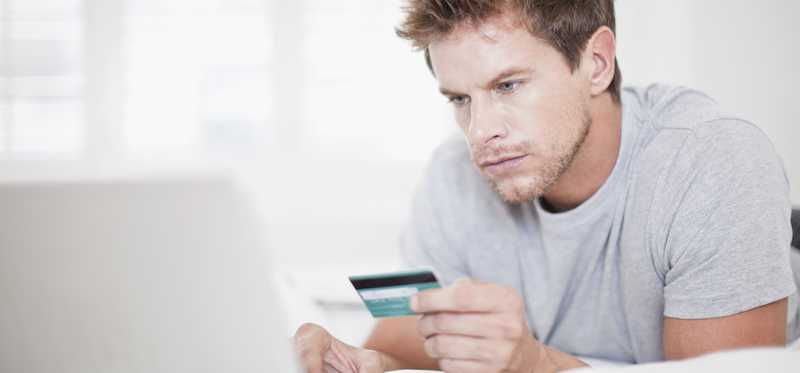Man using his credit card to make an online transaction.