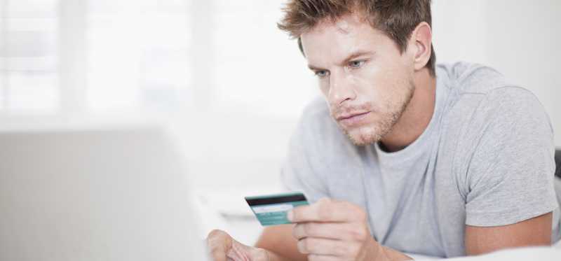Person with credit card on computer.