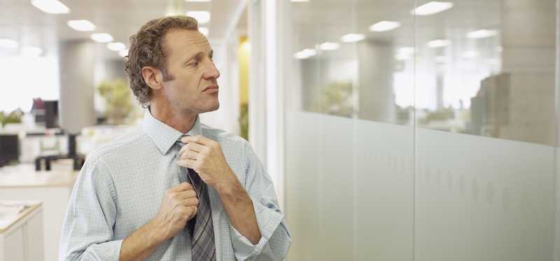 Person with smug expression is adjusting tie.