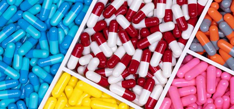 A sectioned tray full of brightly colored pills.