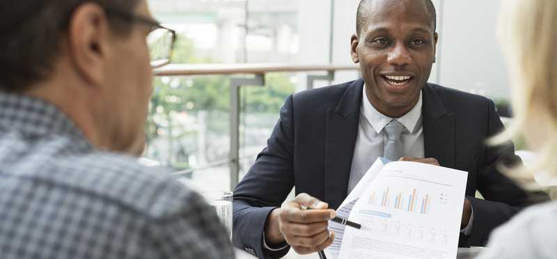 Mature couple talking to financial advisor.