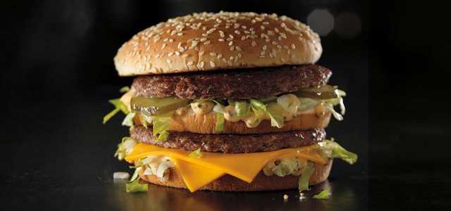 A McDonald's Grand Mac burger sitting on a black surface