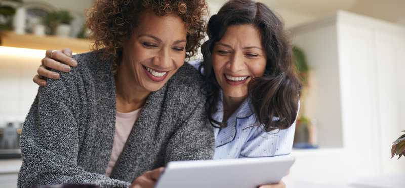 Two people reviewing finances on tablet.
