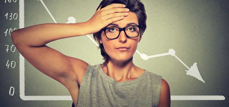 Frustrated woman in front of a downward chart.
