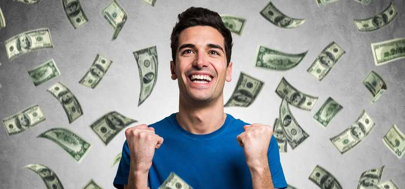 Money raining on person smiling and celebrating.
