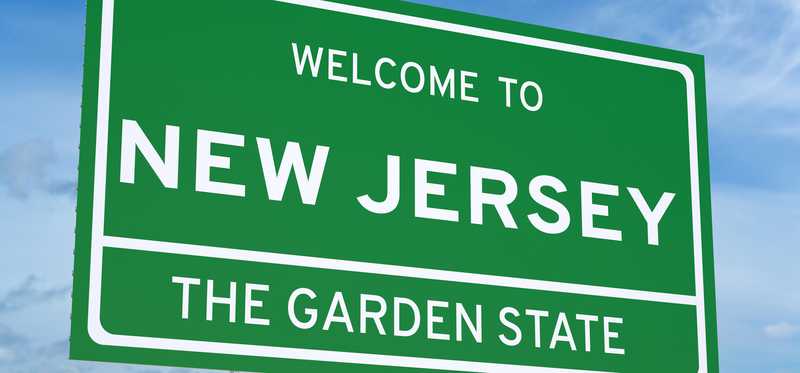 Green road sign that says Welcome to New Jersey, The Garden State.