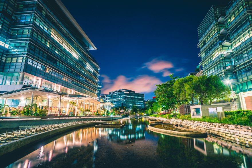 Modern office buildings situated on both sides of a lovely waterway winding itself through Hong Kong.