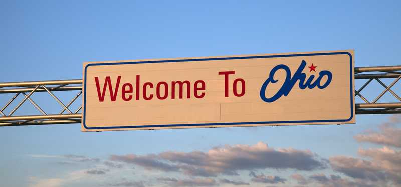 Sign that says Welcome to Ohio hanging above highway.