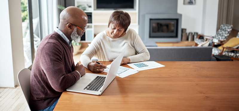 older couple at dining table going over paperwork