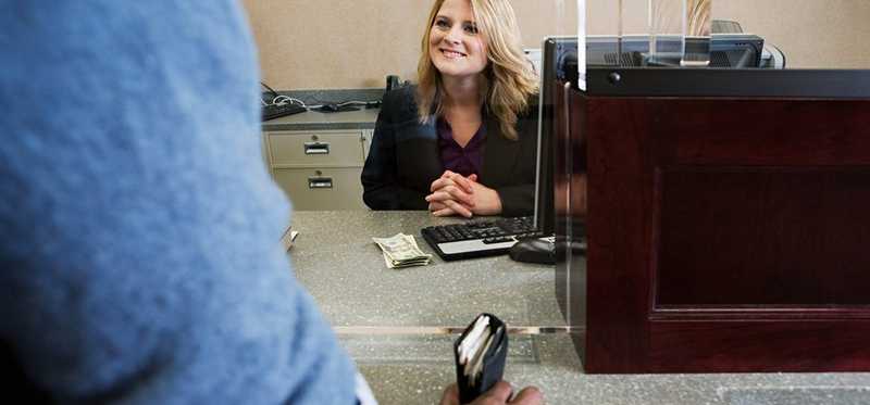 A person speaks with a bank teller.