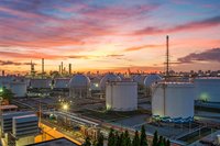 An oil refinery with a sunset in the background.