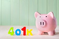 Pink piggy bank sits on the right of the words "401K" on a table.