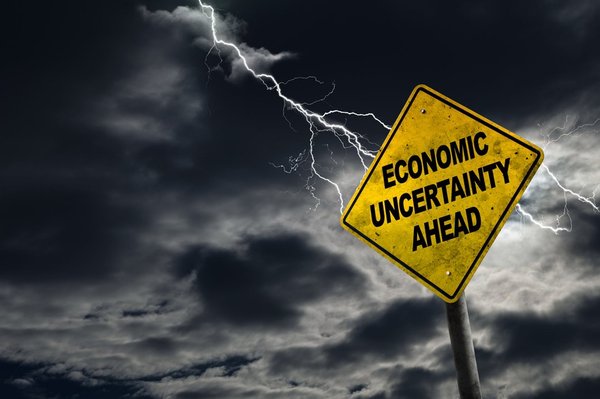 Economic Uncertainty sign against a stormy background with lightning.