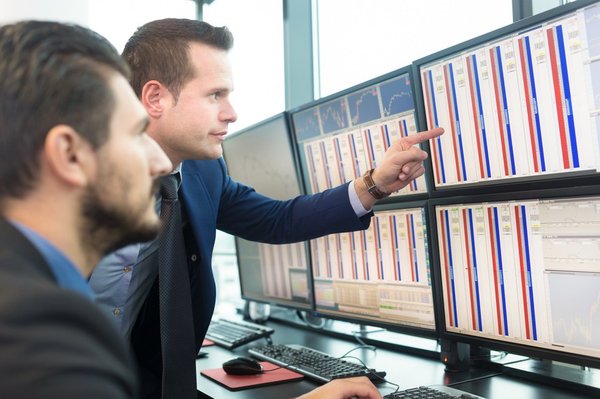 Stock traders looking at monitors.