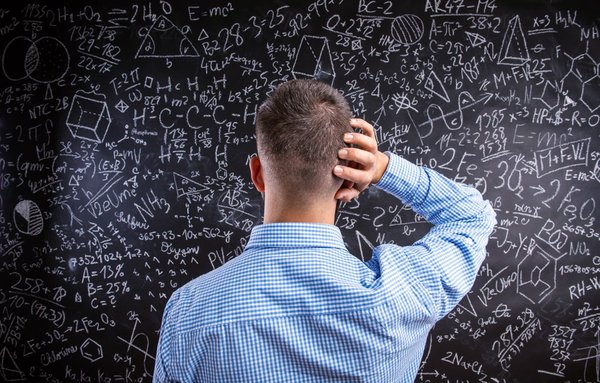 Confused man staring at blackboard filled with equations
