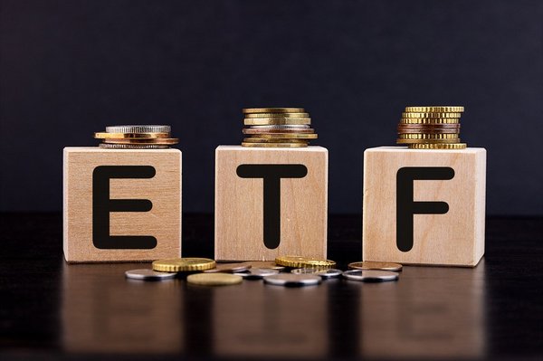Blocks with the letters E, T, and F on them with gold and silver coins around it. 