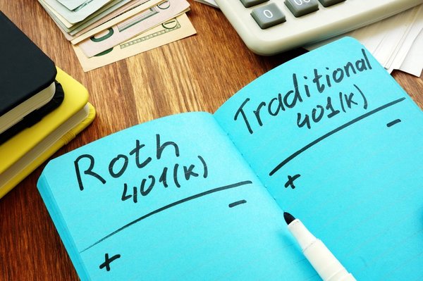 Notebook with a pros and cons list of both Roth 401K and Traditional 401Ks.