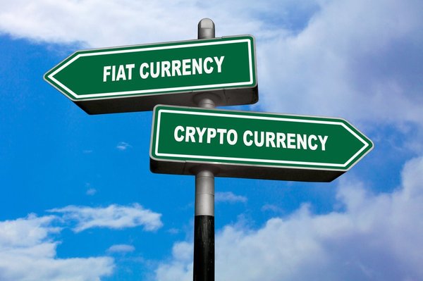 Two signs pointing in different directions, with fiat currency and crypto currency printed on them. 