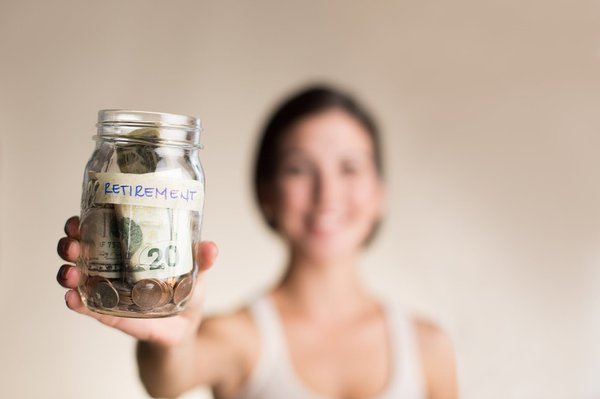 A woman holds her retirement savings in a jar.