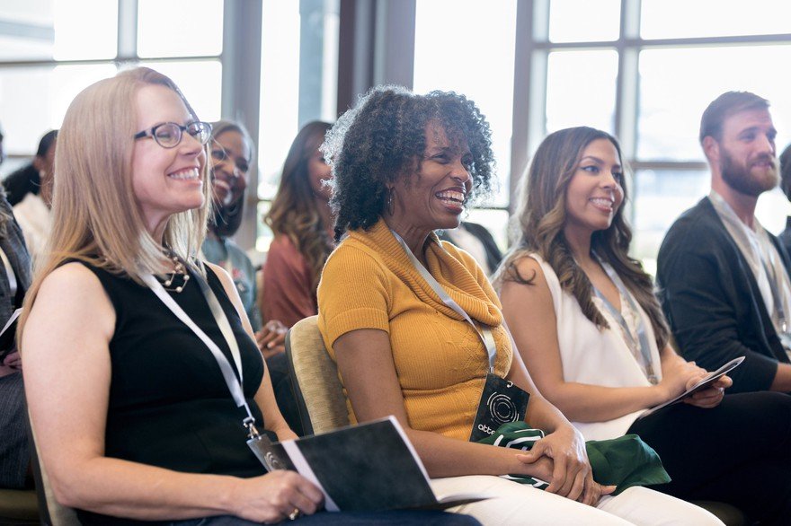 People smiling at a conference.