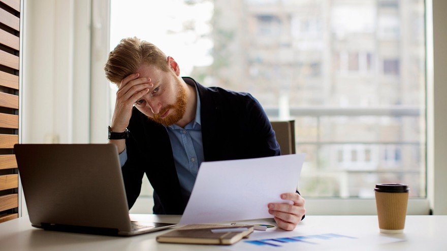 A man looking at research of a bag holder stock.