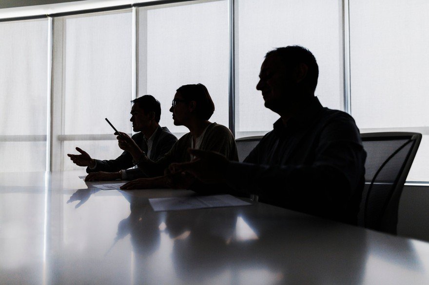 The silhouettes of a board of directors. 