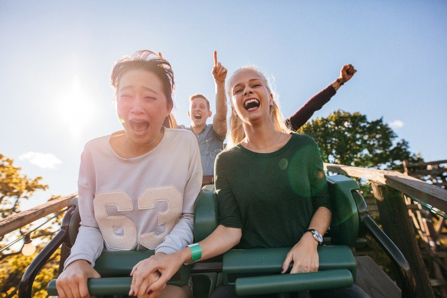 Happy people begin their descent on a roller coaster ride