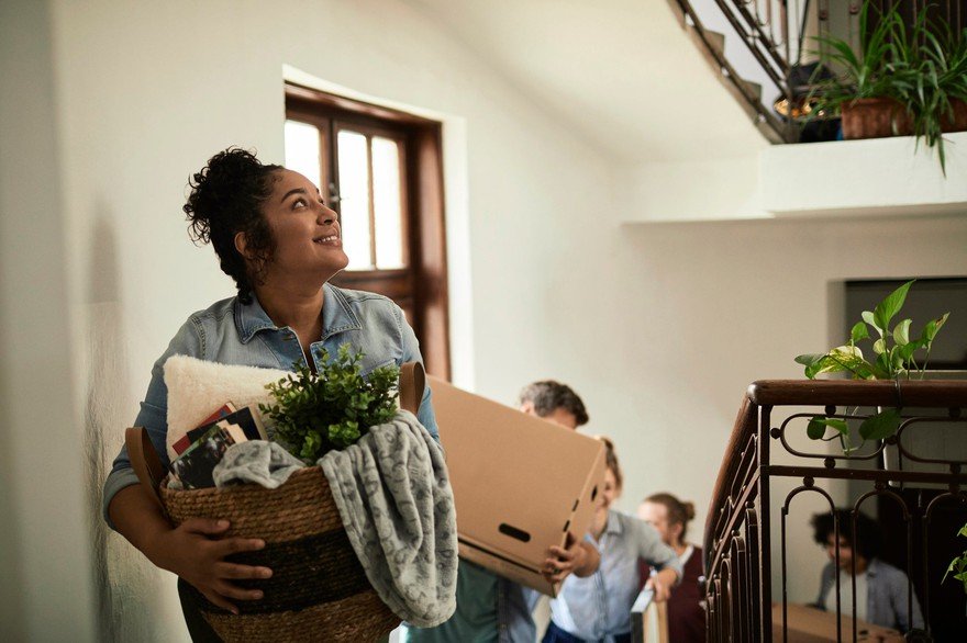 People carry boxes up apartment stairs