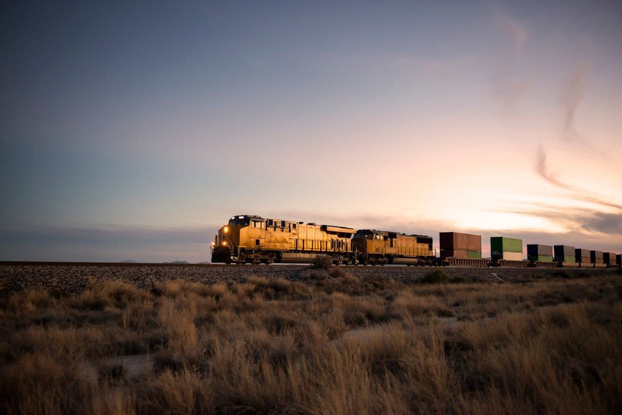 A train rolling through fields. 