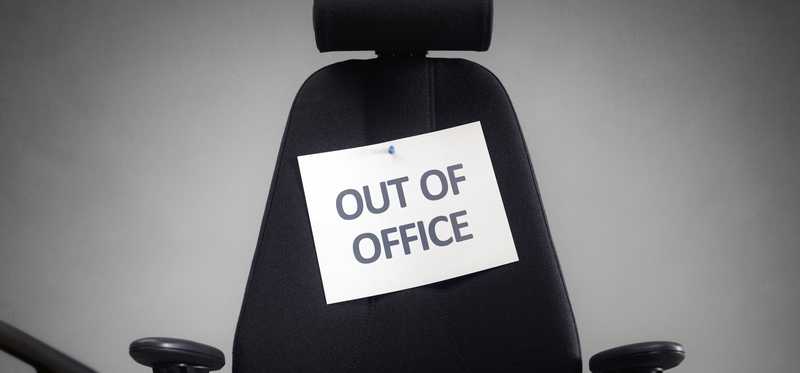 Out of Office sign taped to an office chair.