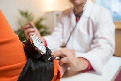 patient having blood pressure measured by doctor