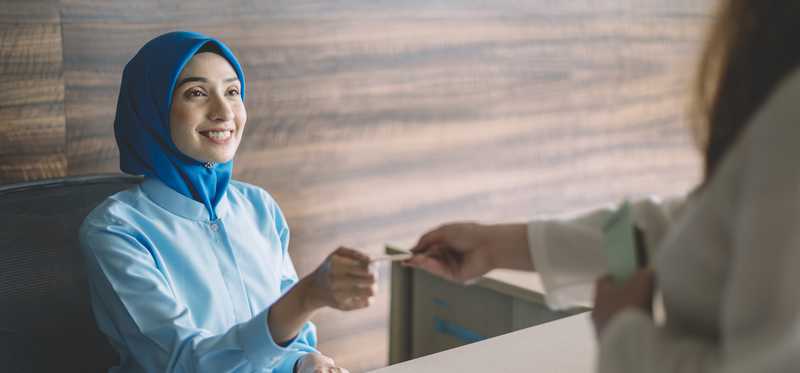 Person pays at medical office with debit card.