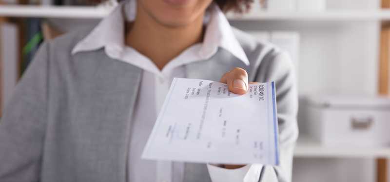 Person handing you a large paper check.